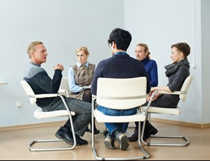 Group of five people talking in a circle